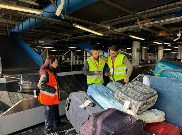 Álvaro y dos colegas revisando maletas en la zona de equipaje